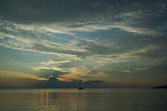 Βάρκα στο ηλιοβασίλεμα και την ανατολή με το δραματικό ουρανό πέρα από τον ωκεανό στοκ εικόνες Βάρκα στο ηλιοβασίλεμα και την ανατολή με το δραματικό ουρανό πέρα από τον ωκεανό στοκ εικόνες