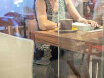 Βιβλίο ανάγνωσης γυναικών στον καφέ στοκ εικόνα Βιβλίο ανάγνωσης γυναικών στον καφέ στοκ εικόνα