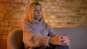 Βλαστός κινηματογραφήσεων σε πρώτο πλάνο της ενήλικης καυκάσιας ξανθής θηλυκής TV προσοχής με την περίεργη έκφραση του προσώπου κ απόθεμα βίντεο Βλαστός κινηματογραφήσεων σε πρώτο πλάνο της ενήλικης καυκάσιας ξανθής θηλυκής TV προσοχής με την περίεργη έκφραση του προσώπου κ απόθεμα βίντεο