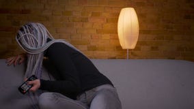 Βλαστός κινηματογραφήσεων σε πρώτο πλάνο της νέας ελκυστικής καυκάσιας συνεδρίασης TV προσοχής hipster θηλυκής στον καναπέ στο εσ απόθεμα βίντεο Βλαστός κινηματογραφήσεων σε πρώτο πλάνο της νέας ελκυστικής καυκάσιας συνεδρίασης TV προσοχής hipster θηλυκής στον καναπέ στο εσ απόθεμα βίντεο
