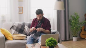 Βράση της συνεδρίασης νεαρών άνδρων στον καναπέ και του σεμιναρίου πλεξίματος προσοχής στο lap-top φιλμ μικρού μήκους Βράση της συνεδρίασης νεαρών άνδρων στον καναπέ και του σεμιναρίου πλεξίματος προσοχής στο lap-top φιλμ μικρού μήκους