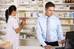 Βρετανικοί νοσοκόμα και φαρμακοποιός που εργάζονται στο φαρμακείο στοκ εικόνες Βρετανικοί νοσοκόμα και φαρμακοποιός που εργάζονται στο φαρμακείο στοκ εικόνες