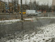 Βροχερή χειμερινή ημέρα στην πόλη, άποψη μέσω ενός υγρού παραθύρου στην οδό στοκ εικόνες Βροχερή χειμερινή ημέρα στην πόλη, άποψη μέσω ενός υγρού παραθύρου στην οδό στοκ εικόνες