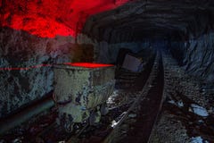 Βρώμικο εγκαταλειμμένο ορυχείο ουράνιου με τη σκουριασμένα ράγα και το καροτσάκι στοκ εικόνες Βρώμικο εγκαταλειμμένο ορυχείο ουράνιου με τη σκουριασμένα ράγα και το καροτσάκι στοκ εικόνες