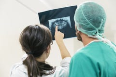 Γιατρός ιατρικής που παρουσιάζει κάτι στον άνδρα συνάδελφός της στην ακτίνα X Στοκ φωτογραφία με δικαίωμα ελεύθερης χρήσης Γιατρός ιατρικής που παρουσιάζει κάτι στον άνδρα συνάδελφός της στην ακτίνα X Στοκ φωτογραφία με δικαίωμα ελεύθερης χρήσης