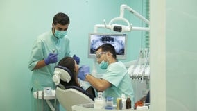 Γιατρός που κάνει την οδοντική θεραπεία στον ασθενή του στην κλινική απόθεμα βίντεο Γιατρός που κάνει την οδοντική θεραπεία στον ασθενή του στην κλινική απόθεμα βίντεο
