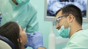 Γιατρός που κάνει την οδοντική θεραπεία στον ασθενή του στην κλινική απόθεμα βίντεο Γιατρός που κάνει την οδοντική θεραπεία στον ασθενή του στην κλινική απόθεμα βίντεο