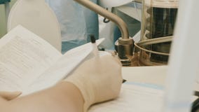 Γιατρός που φορά τη προστατευτική ενδυμασία που εκτελεί τη χειρουργική επέμβαση που χρησιμοποιεί τον αποστειρωμένο εξοπλισμό απόθεμα βίντεο Γιατρός που φορά τη προστατευτική ενδυμασία που εκτελεί τη χειρουργική επέμβαση που χρησιμοποιεί τον αποστειρωμένο εξοπλισμό απόθεμα βίντεο