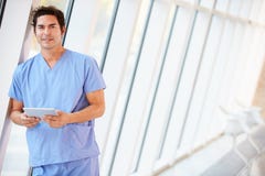 Γιατρός που χρησιμοποιεί την ψηφιακή ταμπλέτα στο διάδρομο του σύγχρονου νοσοκομείου στοκ εικόνα με δικαίωμα ελεύθερης χρήσης Γιατρός που χρησιμοποιεί την ψηφιακή ταμπλέτα στο διάδρομο του σύγχρονου νοσοκομείου στοκ εικόνα με δικαίωμα ελεύθερης χρήσης
