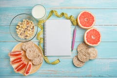 Γκρέιπφρουτ, ψωμί muesli, και ένα καθαρό σημειωματάριο για το γράψιμο Η έννοια της διατροφής στοκ φωτογραφία Γκρέιπφρουτ, ψωμί muesli, και ένα καθαρό σημειωματάριο για το γράψιμο Η έννοια της διατροφής στοκ φωτογραφία