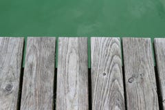 Γκρίζα σανίδα πέρα από το πράσινο νερό στοκ εικόνες Γκρίζα σανίδα πέρα από το πράσινο νερό στοκ εικόνες