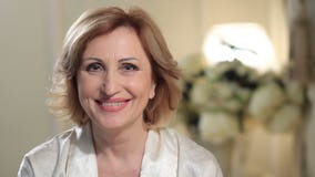 Γοητεία της ανώτερης κυρίας που χαμογελά και που εξετάζει τη κάμερα Γοητεία της ανώτερης κυρίας που χαμογελά και που εξετάζει τη κάμερα
