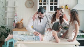 Γονείς και κόρες που λερώνονται στο αλεύρι στην κουζίνα, γέλιο, παιχνίδι, σε αργή κίνηση φιλμ μικρού μήκους Γονείς και κόρες που λερώνονται στο αλεύρι στην κουζίνα, γέλιο, παιχνίδι, σε αργή κίνηση φιλμ μικρού μήκους