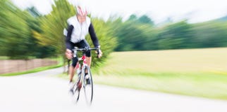 Γρήγορος αθλητισμός Bicyclist στο ποδήλατο με τη θαμπάδα κινήσεων Στοκ Φωτογραφίες Γρήγορος αθλητισμός Bicyclist στο ποδήλατο με τη θαμπάδα κινήσεων Στοκ Φωτογραφίες