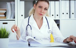 Γραφειοκρατία στο νοσοκομείο Νέα θηλυκή εργασία γιατρών με τους σωρούς των αρχείων στοκ φωτογραφίες με δικαίωμα ελεύθερης χρήσης Γραφειοκρατία στο νοσοκομείο Νέα θηλυκή εργασία γιατρών με τους σωρούς των αρχείων στοκ φωτογραφίες με δικαίωμα ελεύθερης χρήσης