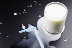 Γυαλί του ραντίσματος γάλακτος και του αχύρου σωλήνων στον πίνακα στοκ φωτογραφίες με δικαίωμα ελεύθερης χρήσης Γυαλί του ραντίσματος γάλακτος και του αχύρου σωλήνων στον πίνακα στοκ φωτογραφίες με δικαίωμα ελεύθερης χρήσης