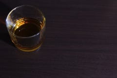 Γυαλί με το ρούμι που απομονώνεται σε έναν σκοτεινό ξύλινο πίνακα στοκ εικόνα Γυαλί με το ρούμι που απομονώνεται σε έναν σκοτεινό ξύλινο πίνακα στοκ εικόνα