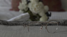 Γυαλιά και ανθοδέσμη του μακρο πυροβολισμού ολισθαινόντων ρυθμιστών νυφών απόθεμα βίντεο Γυαλιά και ανθοδέσμη του μακρο πυροβολισμού ολισθαινόντων ρυθμιστών νυφών απόθεμα βίντεο