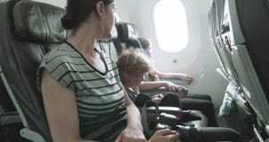 Γυναίκα και δύο παιδιά κάθονται σε ένα αεροπλάνο σε ένα ανώμαλο ταξί πέρα από το tarmac απόθεμα βίντεο Γυναίκα και δύο παιδιά κάθονται σε ένα αεροπλάνο σε ένα ανώμαλο ταξί πέρα από το tarmac απόθεμα βίντεο
