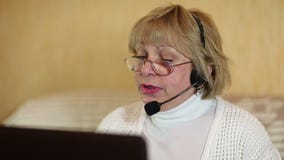 Γυναίκα με τα ακουστικά στις συζητήσεις υπολογιστών σε έναν πελάτη απόθεμα βίντεο Γυναίκα με τα ακουστικά στις συζητήσεις υπολογιστών σε έναν πελάτη απόθεμα βίντεο