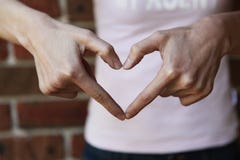Γυναίκα που διαμορφώνει τη μορφή καρδιών με τα χέρια της στοκ φωτογραφία με δικαίωμα ελεύθερης χρήσης Γυναίκα που διαμορφώνει τη μορφή καρδιών με τα χέρια της στοκ φωτογραφία με δικαίωμα ελεύθερης χρήσης