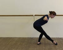 Γυναίκα που κάνει την προθέρμανση στην αίθουσα μπαλέτου στοκ εικόνες Γυναίκα που κάνει την προθέρμανση στην αίθουσα μπαλέτου στοκ εικόνες