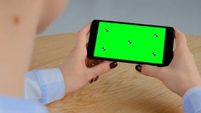 Γυναίκα που κρατά το μαύρο smartphone με την κενή πράσινη οθόνη - βασική έννοια χρώματος φιλμ μικρού μήκους Γυναίκα που κρατά το μαύρο smartphone με την κενή πράσινη οθόνη - βασική έννοια χρώματος φιλμ μικρού μήκους