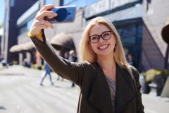 Γυναίκα που παίρνει selfie χρησιμοποιώντας την κινητή κάμερα στην πόλη στοκ εικόνες με δικαίωμα ελεύθερης χρήσης Γυναίκα που παίρνει selfie χρησιμοποιώντας την κινητή κάμερα στην πόλη στοκ εικόνες με δικαίωμα ελεύθερης χρήσης