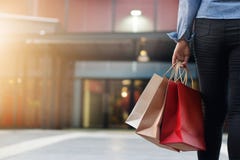 Γυναίκα που περπατά με τις τσάντες αγορών στο υπόβαθρο λεωφόρων αγορών Γυναίκα που περπατά με τις τσάντες αγορών στο υπόβαθρο λεωφόρων αγορών