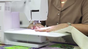 Γυναίκα που ράβει χρησιμοποιώντας την ηλεκτρική μηχανή απόθεμα βίντεο Γυναίκα που ράβει χρησιμοποιώντας την ηλεκτρική μηχανή απόθεμα βίντεο