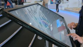 Γυναίκα που χρησιμοποιεί τη διαλογική επίδειξη οθονών επαφής στην αστική έκθεση απόθεμα βίντεο Γυναίκα που χρησιμοποιεί τη διαλογική επίδειξη οθονών επαφής στην αστική έκθεση απόθεμα βίντεο