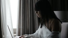Γυναίκα που χρησιμοποιεί το lap-top στο δωμάτιο φιλμ μικρού μήκους Γυναίκα που χρησιμοποιεί το lap-top στο δωμάτιο φιλμ μικρού μήκους