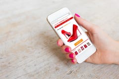 Γυναίκα που χρησιμοποιεί το smartphone για να αγοράσει τα παπούτσια on-line στοκ εικόνες με δικαίωμα ελεύθερης χρήσης Γυναίκα που χρησιμοποιεί το smartphone για να αγοράσει τα παπούτσια on-line στοκ εικόνες με δικαίωμα ελεύθερης χρήσης