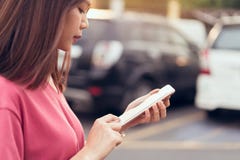 Γυναίκα που χρησιμοποιεί το smartphone για την εφαρμογή στο υπόβαθρο θαμπάδων αυτοκινήτων στοκ φωτογραφία με δικαίωμα ελεύθερης χρήσης Γυναίκα που χρησιμοποιεί το smartphone για την εφαρμογή στο υπόβαθρο θαμπάδων αυτοκινήτων στοκ φωτογραφία με δικαίωμα ελεύθερης χρήσης