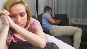γυναίκα προβλημάτων ανδρών κρίσης ζευγών Ο άνδρας και η γυναίκα περνούν το βράδυ στο καθιστικό στον καναπέ ο άνδρας χρησιμοποιεί απόθεμα βίντεο γυναίκα προβλημάτων ανδρών κρίσης ζευγών Ο άνδρας και η γυναίκα περνούν το βράδυ στο καθιστικό στον καναπέ ο άνδρας χρησιμοποιεί απόθεμα βίντεο