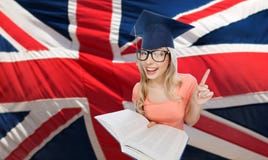 Γυναίκα σπουδαστών στο mortarboard πέρα από την αγγλική σημαία Στοκ Φωτογραφίες Γυναίκα σπουδαστών στο mortarboard πέρα από την αγγλική σημαία Στοκ Φωτογραφίες