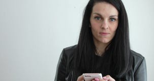 Γυναίκα στο μαύρο σακάκι δέρματος που στέλνει το μήνυμα στο τηλέφωνο κυττάρων φιλμ μικρού μήκους Γυναίκα στο μαύρο σακάκι δέρματος που στέλνει το μήνυμα στο τηλέφωνο κυττάρων φιλμ μικρού μήκους