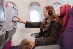 Γυναίκα σχετικά με την οθόνη ψυχαγωγίας LCD στο χρόνο αεροπλάνων κατά την πτήση στοκ εικόνα με δικαίωμα ελεύθερης χρήσης Γυναίκα σχετικά με την οθόνη ψυχαγωγίας LCD στο χρόνο αεροπλάνων κατά την πτήση στοκ εικόνα με δικαίωμα ελεύθερης χρήσης