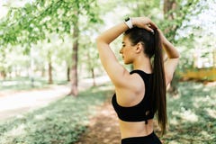 Δένοντας τρίχα γυναικών στο ponytail που παίρνει έτοιμο για την άσκηση στο πάρκο Όμορφη νέα φίλαθλη γυναίκα που συνδέει την μακρυ στοκ εικόνες Δένοντας τρίχα γυναικών στο ponytail που παίρνει έτοιμο για την άσκηση στο πάρκο Όμορφη νέα φίλαθλη γυναίκα που συνδέει την μακρυ στοκ εικόνες