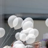 Δέσμη των άσπρων μπαλονιών ηλίου στις σειρές σε ένα υπαίθριο γεγονός, με τη διπλή έκθεση στοκ εικόνα Δέσμη των άσπρων μπαλονιών ηλίου στις σειρές σε ένα υπαίθριο γεγονός, με τη διπλή έκθεση στοκ εικόνα
