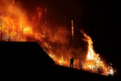 Δασική πυρκαγιά κοντά σε ένα σπίτι, σκιαγραφία πυροσβεστών στοκ φωτογραφία Δασική πυρκαγιά κοντά σε ένα σπίτι, σκιαγραφία πυροσβεστών στοκ φωτογραφία