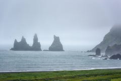 Διάσημοι σχηματισμοί βράχου Reynisdrangar, troll δάχτυλα στη μαύρη παραλία Reynisfjara άμμου, ομιχλώδες τοπίο, Ισλανδία στοκ φωτογραφία Διάσημοι σχηματισμοί βράχου Reynisdrangar, troll δάχτυλα στη μαύρη παραλία Reynisfjara άμμου, ομιχλώδες τοπίο, Ισλανδία στοκ φωτογραφία