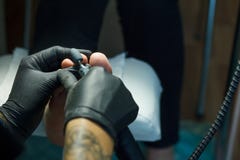 Διαδικασία επεξεργασίας δερμάτων ποδιών Φορημένα γάντια χέρια με μια μηχανή pedicure E στοκ εικόνες Διαδικασία επεξεργασίας δερμάτων ποδιών Φορημένα γάντια χέρια με μια μηχανή pedicure E στοκ εικόνες