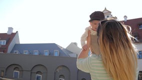 Διακινούμενα με τα παιδιά, mom τα παιχνίδια με το γιο στα όπλα του αυξάνουν το και έπειτα τις περιστροφές στο backlight απόθεμα βίντεο Διακινούμενα με τα παιδιά, mom τα παιχνίδια με το γιο στα όπλα του αυξάνουν το και έπειτα τις περιστροφές στο backlight απόθεμα βίντεο