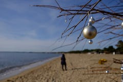 Διακόσμηση Χριστουγέννων στην παραλία σε μια ηλιόλουστη ημέρα με το θολωμένο περπάτημα γυναικών στοκ εικόνα με δικαίωμα ελεύθερης χρήσης Διακόσμηση Χριστουγέννων στην παραλία σε μια ηλιόλουστη ημέρα με το θολωμένο περπάτημα γυναικών στοκ εικόνα με δικαίωμα ελεύθερης χρήσης