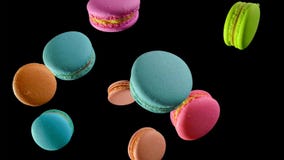 Διαφορετικοί τύποι macaroons στην κίνηση που αφορά το σκοτεινό υπόβαθρο στοκ εικόνα Διαφορετικοί τύποι macaroons στην κίνηση που αφορά το σκοτεινό υπόβαθρο στοκ εικόνα