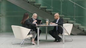 Διοικητικοί συνεργάτες που συναντιούνται στο λόμπι του σύγχρονου κτιρίου γραφείων Διοικητικοί συνεργάτες που συναντιούνται στο λόμπι του σύγχρονου κτιρίου γραφείων