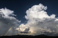 Δραματικός ουρανός με το τεράστιο σκοτεινό άσπρο σύννεφο και το καταπληκτικό ουράνιο τόξο στοκ φωτογραφίες Δραματικός ουρανός με το τεράστιο σκοτεινό άσπρο σύννεφο και το καταπληκτικό ουράνιο τόξο στοκ φωτογραφίες