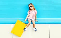 Δροσερό παιδί μόδας με την τσάντα αγορών στο ζωηρόχρωμο μπλε υπόβαθρο στοκ φωτογραφία με δικαίωμα ελεύθερης χρήσης Δροσερό παιδί μόδας με την τσάντα αγορών στο ζωηρόχρωμο μπλε υπόβαθρο στοκ φωτογραφία με δικαίωμα ελεύθερης χρήσης