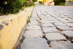 Δρόμος πόλεων που ευθυγραμμίζεται με τους φραγμούς πετρών Κίτρινα σύνορα r στοκ φωτογραφία με δικαίωμα ελεύθερης χρήσης Δρόμος πόλεων που ευθυγραμμίζεται με τους φραγμούς πετρών Κίτρινα σύνορα r στοκ φωτογραφία με δικαίωμα ελεύθερης χρήσης